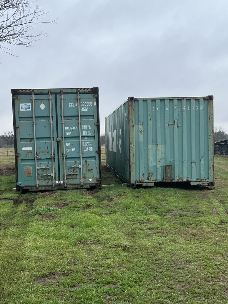 High cube and standard shipping containers in a rural landscape